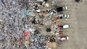 Aerial view of a landfill with scattered trash and vehicles.