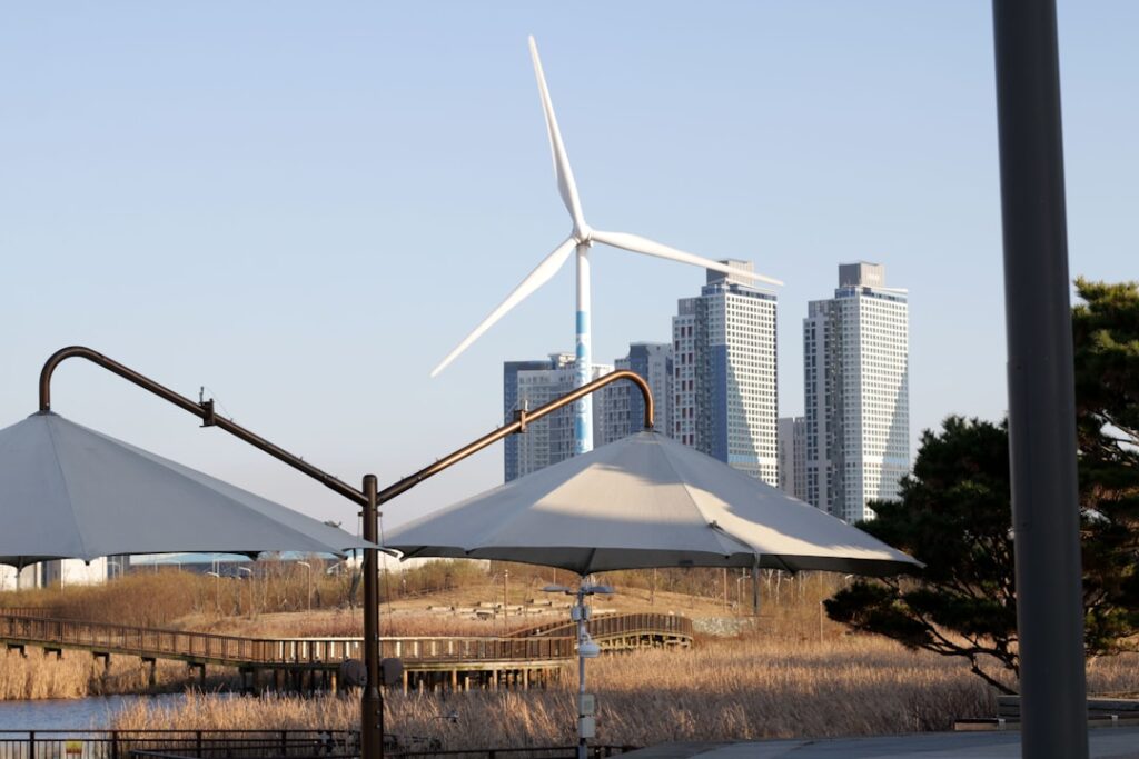 Wind turbine and modern buildings by the water.