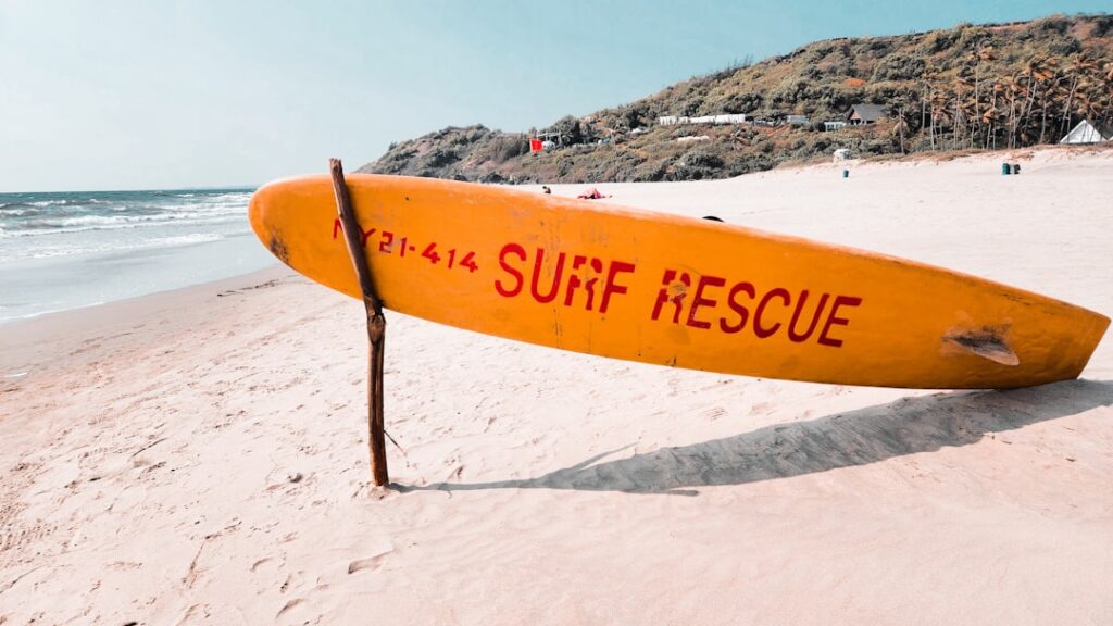 a surfboard leaning up against a pole on a beach