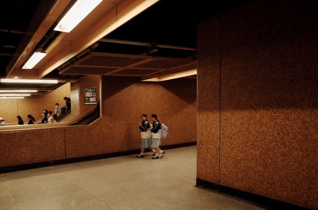 Two people walk down a subway corridor.