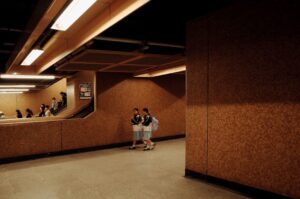 Two people walk down a subway corridor.